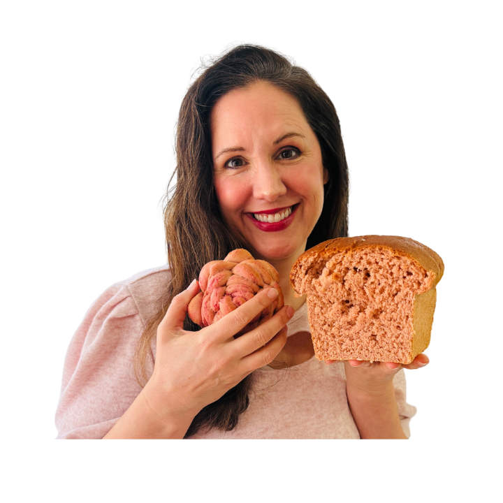 woman holding pink fresh milled flour bread loaf and rose rolls