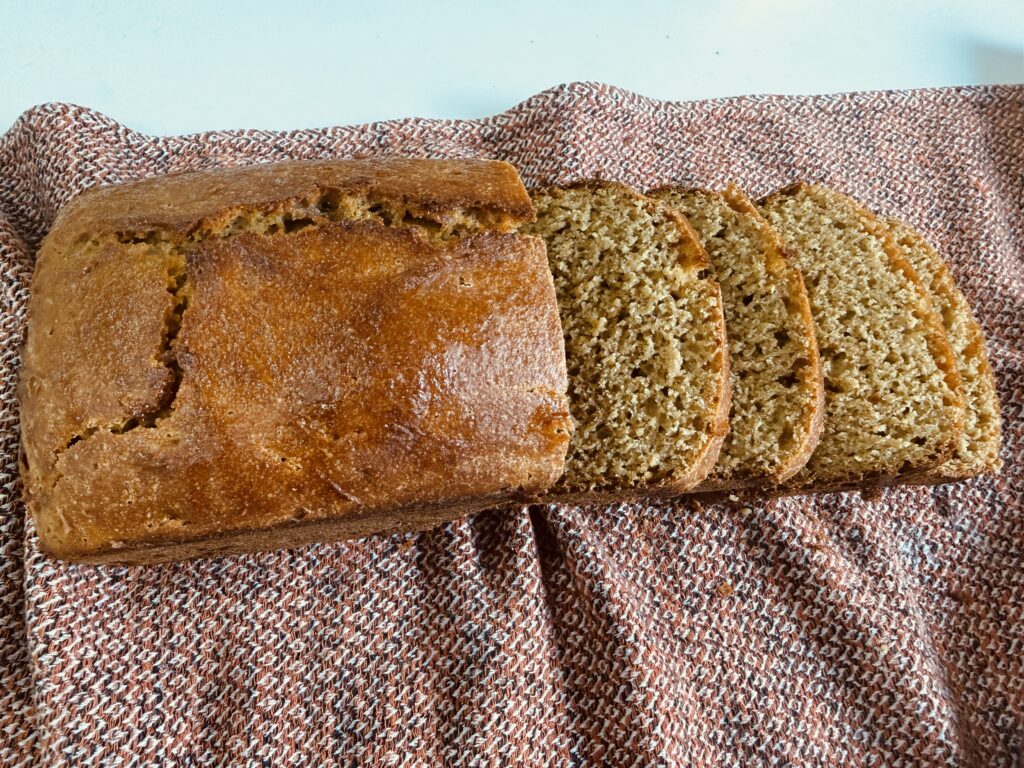 Sliced einkorn sourdough sandwich bread loaf on a linen towel showing soft crumb